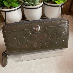 Coach zip-around wallet in a gray or olive green embossed patent leather